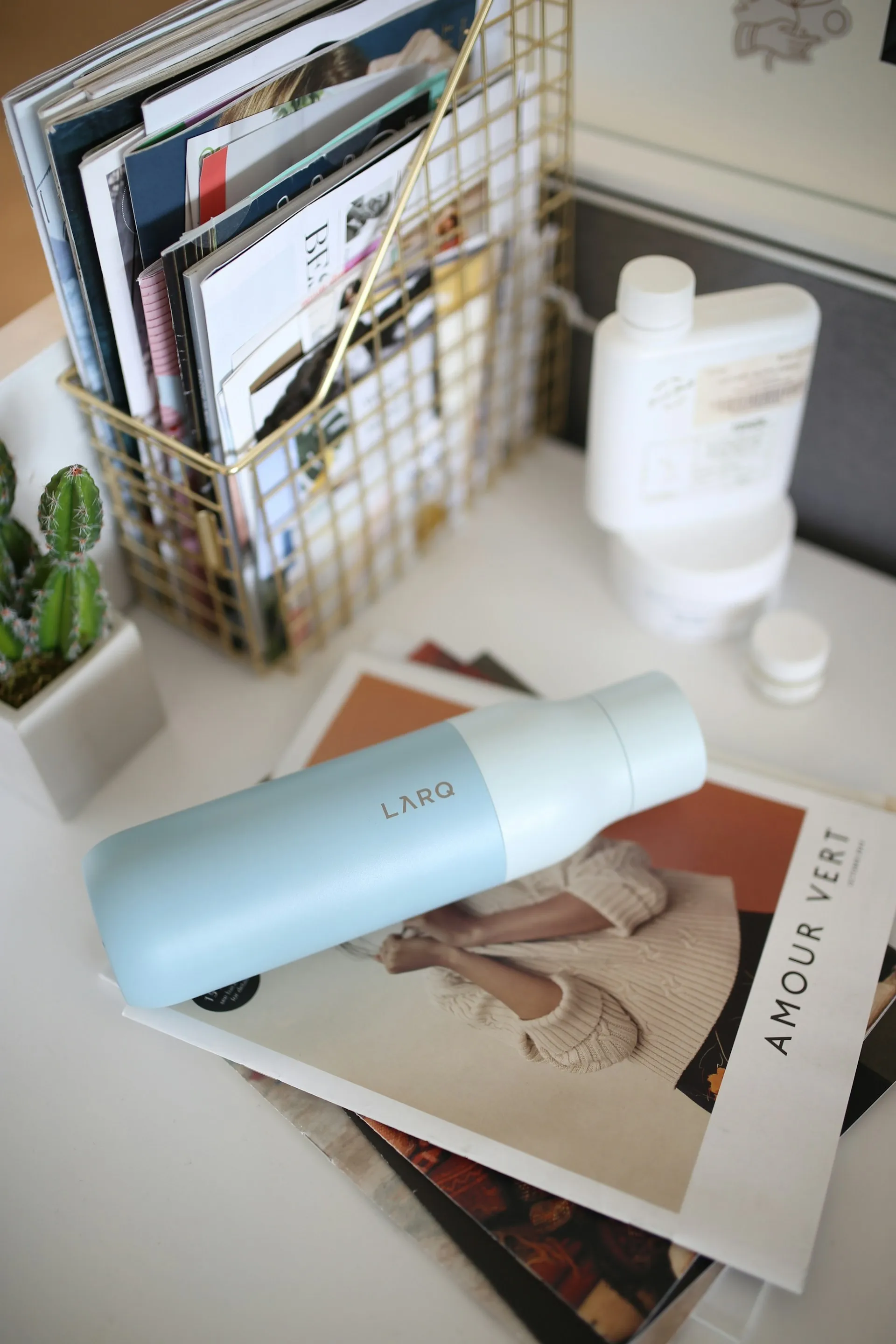 Water bottle on an office desk beside a laptop